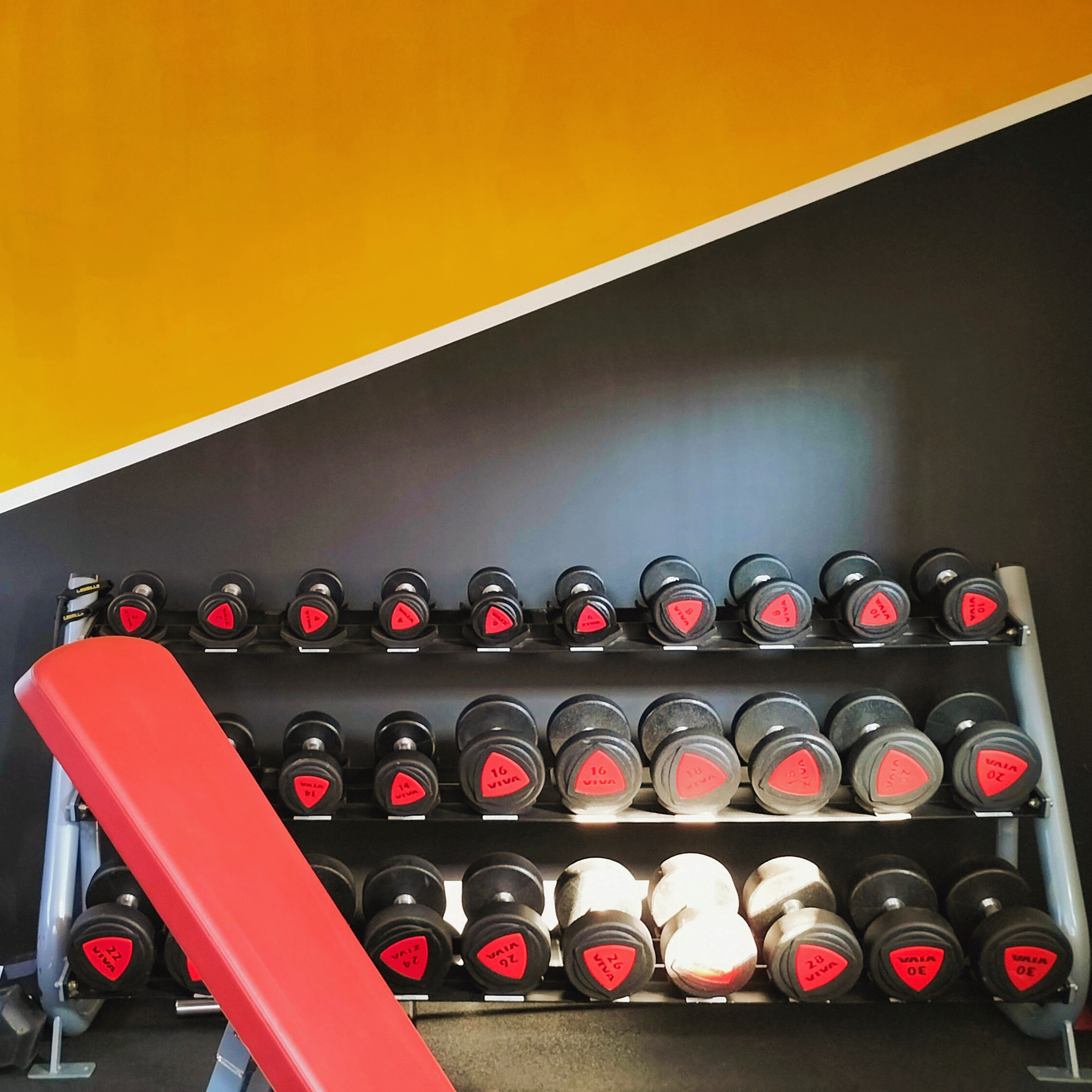 images salle de sport fond jaune avec rack à haltère